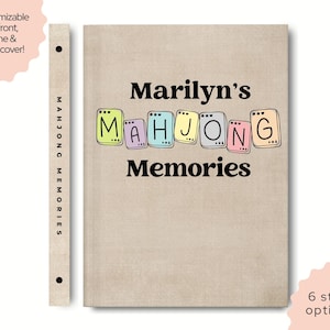 May include: A beige Mahjong Memories journal with the text "Marilyn's Mahjong Memories" in black and colorful letters. The spine reads "Mahjong Memories". The image also includes text that says "Customizable on front, spine & back cover!" and "6 style options".