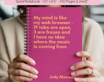 May include: A magenta spiral notebook measuring 5.5 inches by 8.5 inches with 100 lined pages. The cover features orange text that reads: My mind is like my web browser - 19 tabs are open, 3 are frozen and I have no idea where the music is coming from. Judy Maxwell.