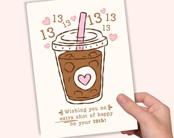 May include: A greeting card featuring a brown iced coffee in a clear plastic cup with a pink straw, surrounded by small pink hearts and the number 13 repeated multiple times. The text reads, Wishing you an extra shot of happy on your 13th!
