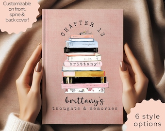 May include: A dusty rose hardcover book featuring a stack of illustrated books in the center. The text reads CHAPTER 13, brittany, and brittany's thoughts & memories. The cover includes a floral pattern on the bottom book and various colors.