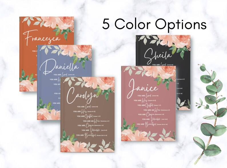 May include: Five hardback journals in different colours including rust, blue, brown, black, and mauve. Each journal features a floral design with peach-coloured flowers and green leaves, a custom name, and the text You Are Loved, His, Chosen, Heir, Valuable, and Beautiful.