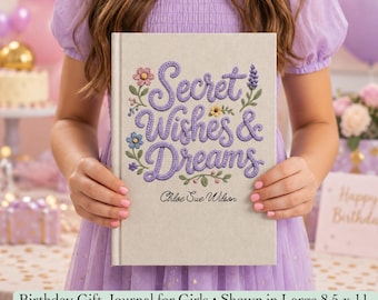 May include: A hardcover journal with a light beige cover featuring purple embroidered-style text that reads Secret Wishes & Dreams, accented by small floral illustrations and the name Chloe Sue Wilson, measuring 8.5 by 11 inches.
