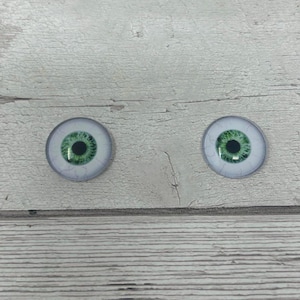 May include: Two round, white, plastic doll eyes with green irises and black pupils.