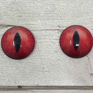 May include: Two red glass eyes with black pupils. The eyes are round and have a glossy finish.