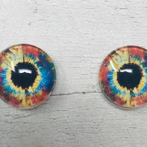 May include: Two colourful glass eyes with black pupils and a white iris with red, yellow and blue accents.