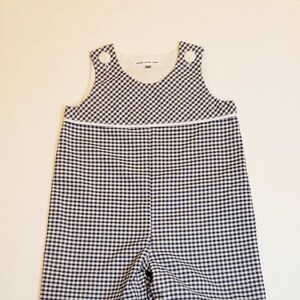 Puede incluir: Un pelele de pana azul y blanco con botones blancos y un ribete blanco. El pelele tiene una etiqueta que dice "Hall and Lux" y "3M".