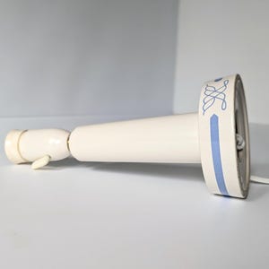 Könnte beinhalten: Weiße Keramik-Tischlampe mit einem blau-weißen gemusterten Sockel. Die Lampe hat ein weißes Kabel und einen weißen Schalter.