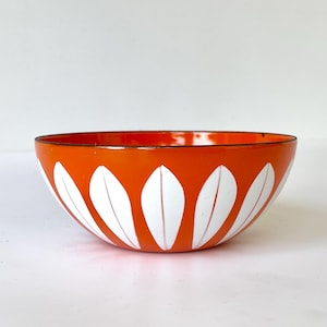 Könnte beinhalten: Orangefarbene Emaille-Schüssel mit einem weißen Blatt-Muster.