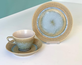 Może przedstawiać: Zestaw vintage ceramicznych filiżanek do herbaty i spodków w niebiesko-brązowej glazurze. Filiżanki i spodki mają unikalny, fakturowany wzór.