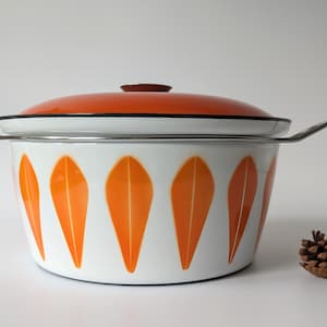 May include: White enamel pot with orange leaf design and a matching orange lid. The pot has two metal handles.