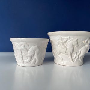 Può includere: Un set di tre tazze in ceramica con finitura opaca e macchiettata. Le tazze sono nei toni del crema, grigio chiaro e grigio scuro. Ogni tazza ha un design semplice e minimalista.