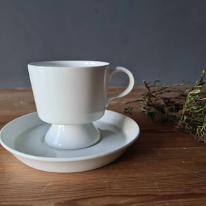 Taza y platillo Arabia Kaj Franck, años 60. Taza blanca con base y platillo. Finlandia. Diseño nórdico retro vintage, MCM moderno de mediados de siglo.