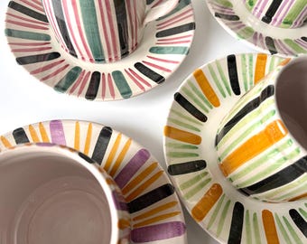 Set aus 8 Keramik Tellern und einem großen Bechern. Dieses fröhliche Set mit Streifen ist handgemalt von Juelsminde keramik, Dänemark 1960-70er Jahre