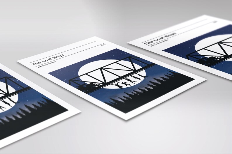 May include: A minimalist poster design featuring a silhouette of a bridge with figures dancing on it, set against a backdrop of a full moon and a starry night sky. The text "The Lost Boys" and "Joel Schumacher" are printed in white at the top of the poster.