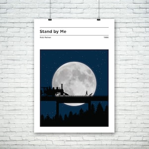 May include: A black and white minimalist poster with the title "Stand by Me" and the director's name "Rob Reiner" and the year "1986". The poster features a silhouette of a train crossing a bridge under a large full moon.