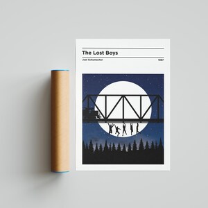 May include: A minimalist poster with a black and white illustration of a bridge with people hanging from it, set against a backdrop of a full moon and a starry night sky. The text "The Lost Boys" is at the top of the poster, with "Joel Schumacher" and "1987" below it.