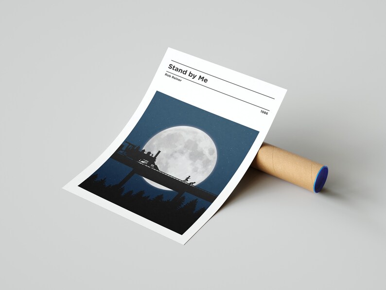 May include: A minimalist movie poster for the film "Stand by Me" directed by Rob Reiner. The poster features a silhouette of a train crossing a bridge under a large, full moon in a dark blue sky.