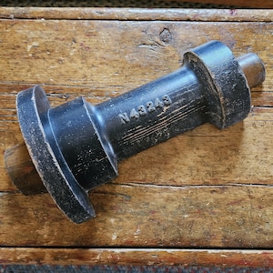 May include: A black wooden object with a round end and a square end. The object has the number "N43243" printed on it.