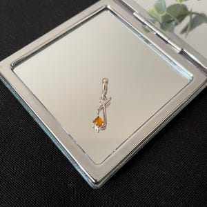 Hermoso collar con colgante de plata de ley 925 con la letra J del alfabeto y ámbar naranja natural en cabujón.