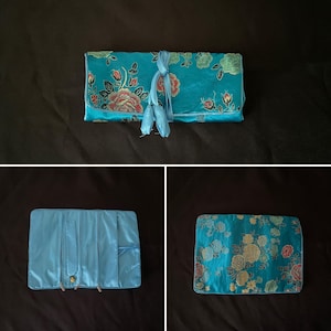 Precioso envoltorio de joyería de seda con bordado floral en azul eléctrico, tres compartimentos con cremallera y bolsillo para regalo.