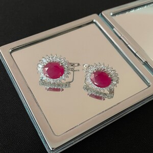 Vackra stora ovala fasetterade naturliga röda rubiner, kubiska zirkonia och örhängen i 925 sterlingsilver, med säkerhetsspärr i 925 sterlingsilver. Gåva