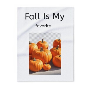 May include: A white rectangular print with the text "Fall Is My favorite" above a cluster of orange pumpkins. The pumpkins vary in size, with a small one in the front.