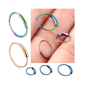 May include: A set of five rainbow-colored hoop earrings. The earrings are made of stainless steel and have a smooth, polished finish. The hoops are available in different sizes.