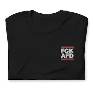 Może przedstawiać: Czarny T-shirt z białym nadrukiem "FCK AFD" w czerwonym prostokącie.