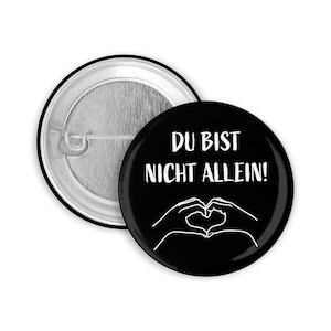 May include: Black button with white text that reads "Du bist nicht allein!" and a white outline of two hands making a heart shape.