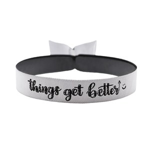 May include: White elastic bracelet with black text that reads "things get better". A smiley face is at the end of the text.