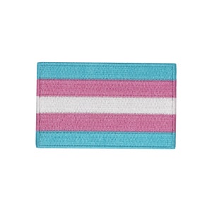 Könnte beinhalten: Ein blauer, rosa und weißer Transgender-Pride-Flaggen-Patch. Der Patch ist aus Stoff und hat einen gestickten Rand.