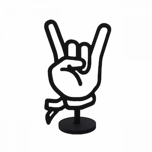 May include: Black metal sculpture of a hand making the rock and roll hand gesture. The hand is on a black pedestal.