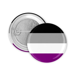 Könnte beinhalten: Ein Knopf mit dem Design der asexuellen Pride-Flagge in Schwarz, Grau, Weiß und Lila.