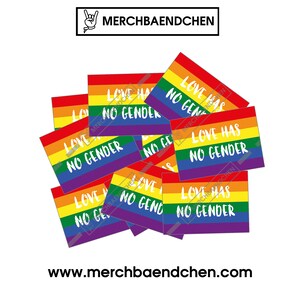 May include: A stack of rainbow-colored stickers with the text "Love Has No Gender" in white. The stickers are arranged in a pile, with some overlapping. The background is white.