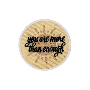Könnte beinhalten: Ein runder, gelber gestickter Aufnäher mit einem Sonnendesign und dem Text "you are more than enough" in Schwarz.