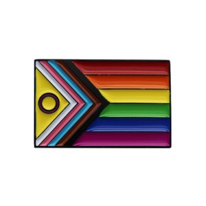 May include: A rainbow pride flag pin with a black and brown chevron in the top left corner and a yellow circle with a black ring in the centre of the chevron.