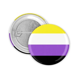 Pode incluir: Um botão redondo com um design listrado amarelo, branco, roxo e preto. O botão representa a bandeira do orgulho não binário.