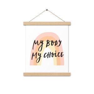 Könnte beinhalten: Ein gerahmter Druck mit einem Regenbogen-Design und dem Text "my body my choice" in schwarzer Schrift.