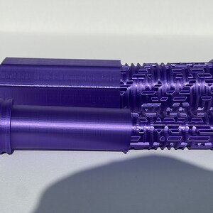May include: Two purple 3D printed rollers with a textured surface. The roller on the top is hexagonal and the roller on the bottom is round.