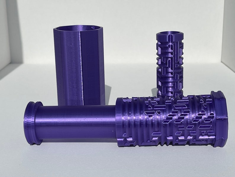 May include: Three purple 3D printed tubes, one with a textured surface and two with smooth surfaces.