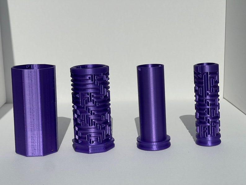 May include: Four purple 3D printed cylindrical containers. Two of the containers have a textured pattern, while the other two are smooth.