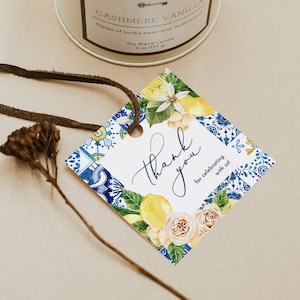 May include: A white gift tag with blue and white patterned border and a watercolor illustration of lemons and roses. The tag says "Thank you for celebrating with us!"