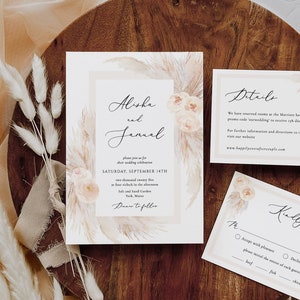 May include: Wedding invitation suite with a beige background and a watercolor design of pampas grass and flowers. The invitation card features the names "Alisha and Januel" and the date "Saturday, September 14th". The RSVP card has a beige background with a watercolor design of pampas grass and flowers. The RSVP card has a checkbox for "Accept with pleasure" and "Decline with regret". The RSVP card also has a checkbox for "Beef", "Fish", and "Chicken".