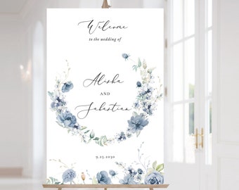 May include: A white wedding welcome sign with a blue watercolor floral wreath. The sign reads "Welcome to the wedding of Alisha and Sebastian 9.23.2019".