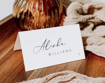 Könnte beinhalten: Weiße Tischkarte mit schwarzem Kalligraphietext, der "Alisha Williams" lautet.