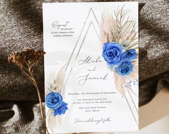 May include: Wedding invitation with a watercolor design featuring blue flowers, pampas grass, and a silver geometric shape. The invitation reads "Request the pleasure of your company at their wedding celebration" and includes the names "Alisha and Jamal", the date "Saturday, the fourteenth of September two thousand twenty five", the time "at four o'clock in the afternoon", the location "Salt and Sand Garden York, Maine", and the phrase "Dinner and dancing to follow".