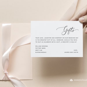 May include: A white card with the word "Gifts" written in cursive. The card lists a few stores where a wedding registry is held, including William Sonoma, Pottery Barn, West Elm, and Bloomingdale's. The card also includes the text "Your love, laughter and company on our wedding day is the greatest gift of all. However, should you wish to help us celebrate with a gift, a registry is held at... Love, Lauren and Justin."