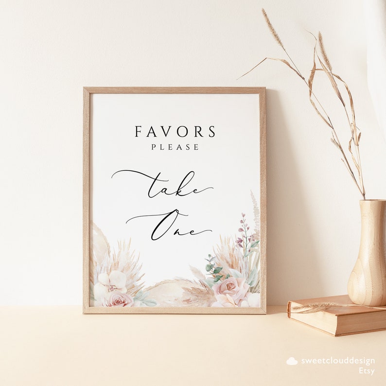 Puede incluir: Un cartel imprimible con un marco de madera marr&oacute;n claro. El cartel tiene un fondo blanco con el texto "Favors Please Take One" en letra cursiva negra. El cartel est&aacute; decorado con una ilustraci&oacute;n de acuarela de hierba de la pampa, hojas de eucalipto y rosas rosas.