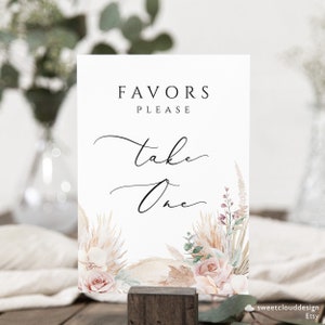 Puede incluir: Un cartel blanco con el texto "Favors Please Take One" en caligraf&iacute;a negra. El cartel est&aacute; decorado con una ilustraci&oacute;n de acuarela de hierba de la pampa seca, rosas rosadas y hojas de eucalipto.
