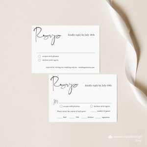 May include: A black and white wedding RSVP card with the name "Royo" written in cursive. The card has two sections, one for accepting or declining the invitation and the other for choosing a meal option. The text "kindly reply by July 10th" is printed on both sections.